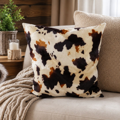 Weicher Kissenbezug aus Fellimitat im beige braunen Kuhflecken Design auf Sofa im gemütlichen Landhausstil